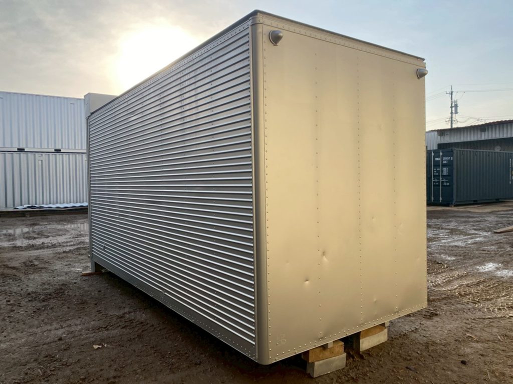 屋外に設置された外付けシャッター仕様の2tアルミコンテナ