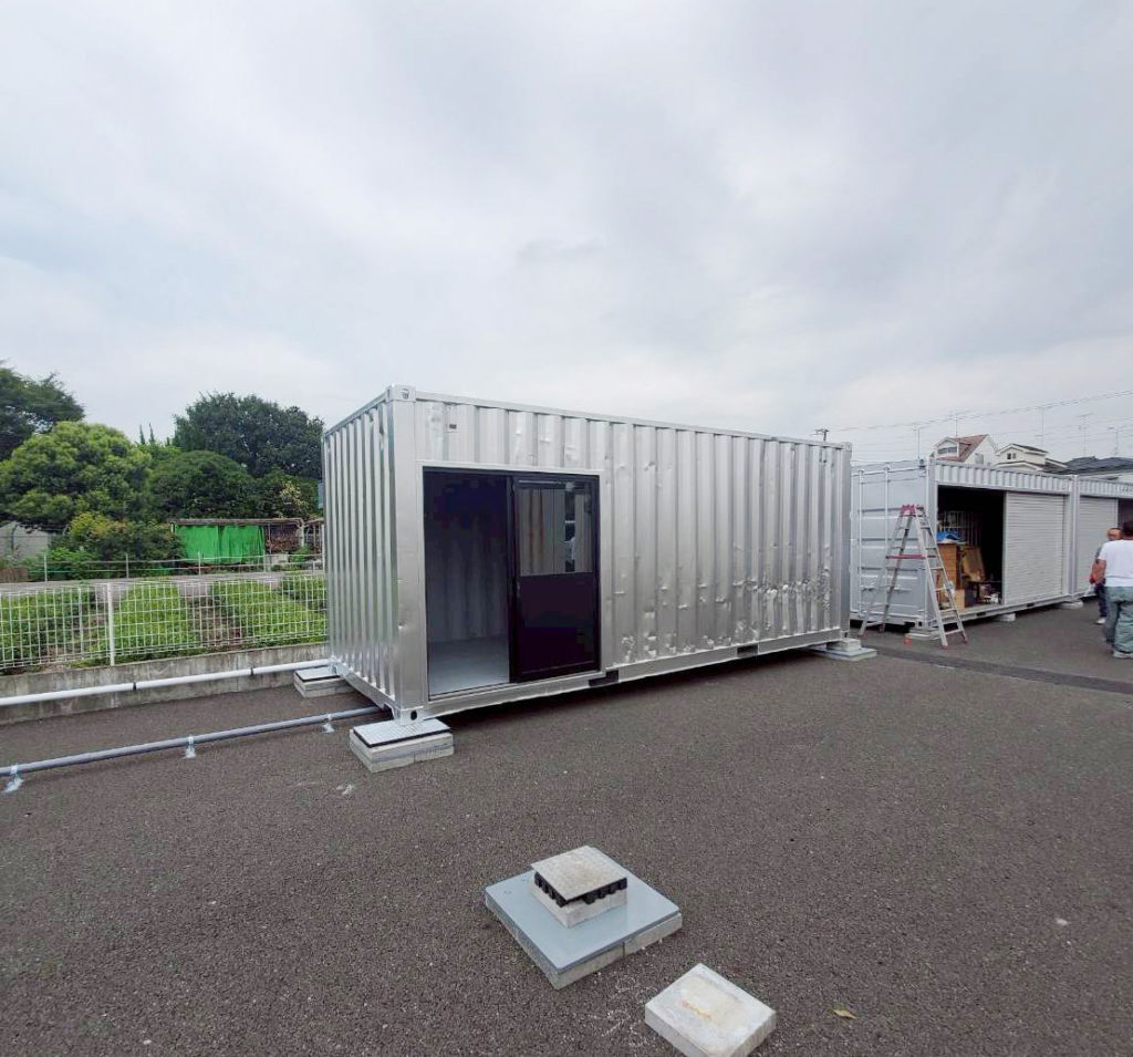 東京都武蔵村山市で納品したシルバー塗装の20ft中古コンテナ。開口改造が施され、倉庫や事務所として利用可能な仕様。